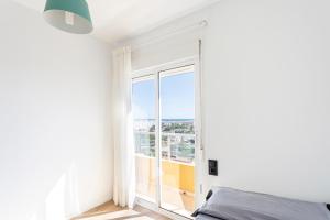 a bedroom with a bed and a large window at Ático en Canet-playa in Canet de Berenguer +20 photos