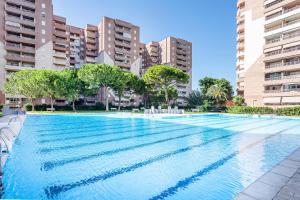 a swimming pool in a city with tall buildings at Ático en Canet-playa in Canet de Berenguer