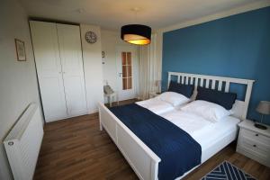 a bedroom with a large bed with a blue wall at Ferienwohnung im Hofratshaus in Schrozberg +21 photos