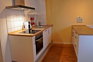 a small kitchen with a stove and a sink at Ferienwohnung im Hofratshaus in Schrozberg