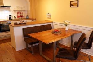 a kitchen with a wooden table and some chairs at Ferienwohnung im Hofratshaus in Schrozberg