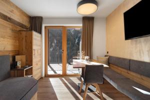 a hotel room with a desk and a television at Chalet-Suite Wiese in Selva dei Molini