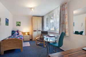 a bedroom with a bed and a desk and a table at Haus Monika in Todtmoos