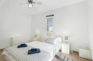 a white bedroom with two beds and a window at Orlando 314 in Adeje +17 photos