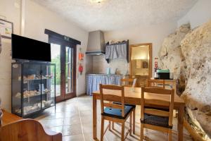a dining room with a table and a stone wall at Quinta do Castelo - Casa de Pedra in Reguengo Grande
