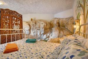 a bedroom with a bed in front of a rock wall at Quinta do Castelo - Casa de Pedra in Reguengo Grande