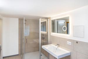 a white bathroom with a sink and a shower at Haus am Eschenbach in Lindenberg +25 photos
