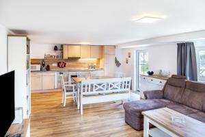 a kitchen and living room with a couch and a table at Haus am Eschenbach in Lindenberg