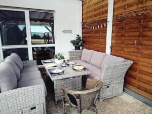 a patio with a table and wicker chairs at Hörselberg Apartment in Hörselberg-Hainich