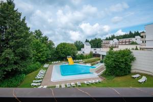 a view of a pool with chairs and a resort at Appartement Hella Wahnsinn in Sankt Englmar
