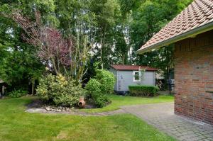 a yard with a brick house and a small shed at Seeschwalbe Hilgenriedersiel in Hagermarsch