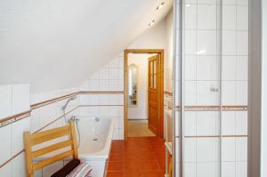 a bathroom with a shower and a bath tub at Seeschwalbe Hilgenriedersiel in Hagermarsch +17 photos