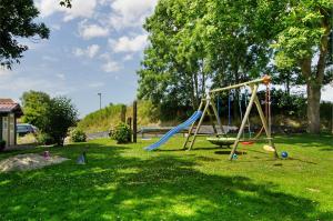 a playground with a slide in the grass at Seeschwalbe Hilgenriedersiel in Hagermarsch
