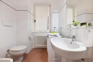 a white bathroom with a sink and a toilet at Lake view Domaso in Domaso +18 photos