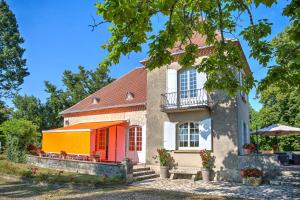 a house with an orange door and a bench at Magnifique maison à Ribérac in Ribérac