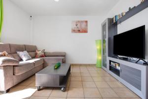 a living room with a couch and a flat screen tv at Apartamento Relax and Dream in Pájara