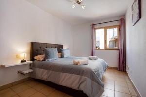 a bedroom with a large bed with a window at Apartamento Relax and Dream in Pájara +13 photos