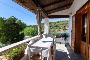a patio with a table and chairs on a balcony at Casa Euforbia in Orosei