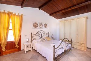 a bedroom with a large bed with a wooden ceiling at Casa Euforbia in Orosei
