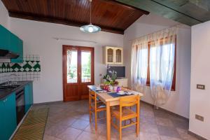 a kitchen with a table and chairs in a room at Casa Euforbia in Orosei