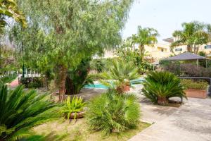 a garden with palm trees and a swimming pool at Gli Archi with pool - Lecce in Lecce
