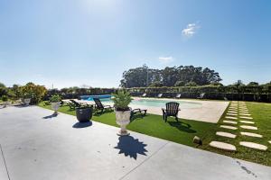 a patio with chairs and a swimming pool at Apartamento Thaï com Piscina in Apúlia