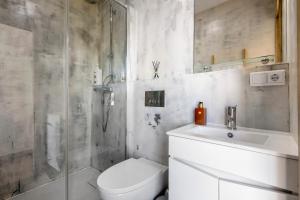 a bathroom with a shower and a toilet and a sink at Apartamento Thaï com Piscina in Apúlia +13 photos