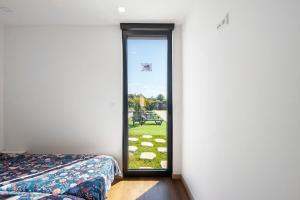 a bedroom with a door leading to a yard at Apartamento Thaï com Piscina in Apúlia