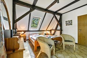 a bedroom with a bed and chairs in a room at Ferienhof Schülp in Schülp