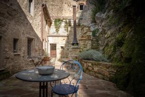 an alley with a table and chairs in a stone building at L'imbrunire in Campiglia dʼOrcia