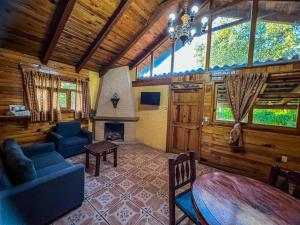 a living room with a couch and a table and a fireplace at La Huerta in Mazamitla