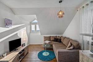 a living room with a couch and a tv at Ferienwohnung Hobmaier in Forstern