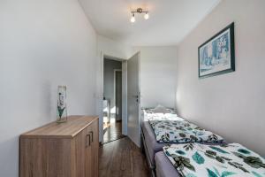 a bedroom with a bed and a wooden dresser at Ferienwohnung Hobmaier in Forstern