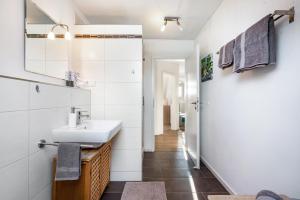 a bathroom with a sink and a mirror at Ferienwohnung Hobmaier in Forstern +17 photos