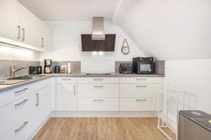 a white kitchen with white cabinets and appliances at Ferienwohnung Stella Maris in Carrenzien