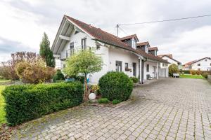 a white house with a brick driveway at Ferienwohnung Hobmaier in Forstern