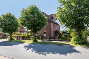 a house with trees on the side of a road at Ferienwohnung Stella Maris in Carrenzien