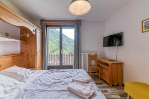 a bedroom with a bed and a desk and a television at Chambre d'hôte Gite Passoud in Oz +73 photos
