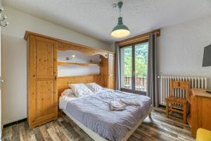 a bedroom with a bed and a desk and a window at Chambre d'hôte Gite Passoud in Oz