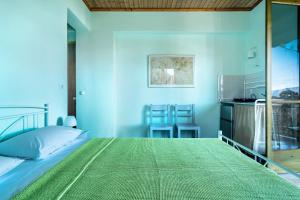 a blue bedroom with a bed and a kitchen at Old Boat double studio 11 in Nikiana