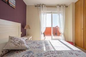 a bedroom with a bed and a window with a view at Apartmento en Torrox Costa in Torrox Costa +18 photos