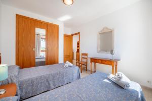 a hotel room with two beds and a desk at Apartamentos Karin 1ºc in Cala d´Or +17 photos