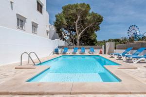 a swimming pool with blue lounge chairs and a pool at Apartamentos Karin 1ºc in Cala d´Or