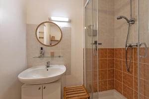 a bathroom with a sink and a shower with a mirror at Appartement 4 pers 50m de la plage in Plougonvelin