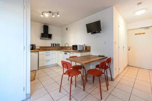 a kitchen with a wooden table and red chairs at Appartement 4 pers 50m de la plage in Plougonvelin +15 photos
