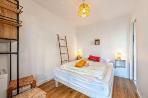 a bedroom with a bed with white sheets and a ladder at Appartement 4 pers 50m de la plage in Plougonvelin