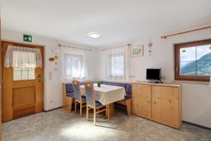 a dining room with a table and chairs and a television at Mattleitenhof in Santa Maddalena