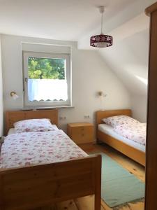 a bedroom with two beds and a window at Mein Ferienhaus Rosenbusch 2 in Kemmern