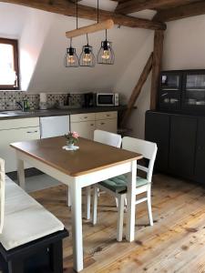a kitchen with a wooden table and white chairs at Mein Ferienhaus Rosenbusch 2 in Kemmern
