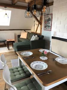 a living room with a table and a couch at Mein Ferienhaus Rosenbusch 2 in Kemmern +15 photos